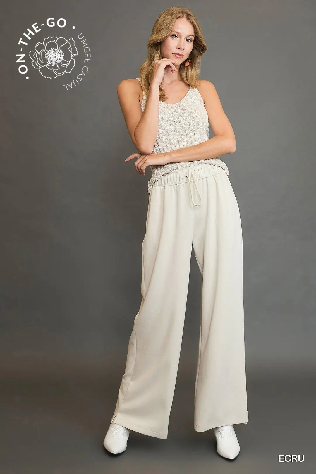 Woman wearing a light-colored outfit with 'On-The-Go' branding on a gray background