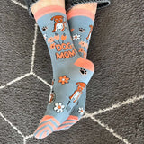 Socks with dog-themed design and 'Dog Mom' text on a textured surface