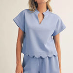 Woman wearing a light blue pajama set with a plain background