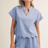 Woman wearing a light blue pajama set with a plain background