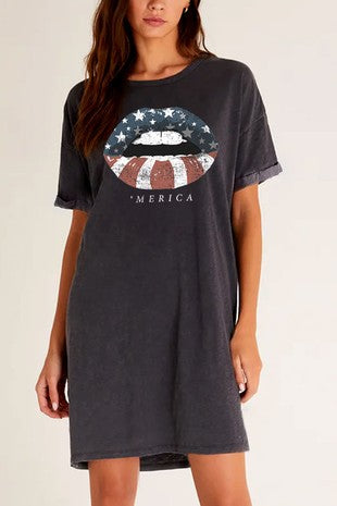 Woman wearing a dark gray t-shirt with a graphic design and text on a plain background