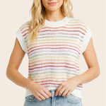 Woman wearing a colorful striped shirt and denim shorts on a plain background