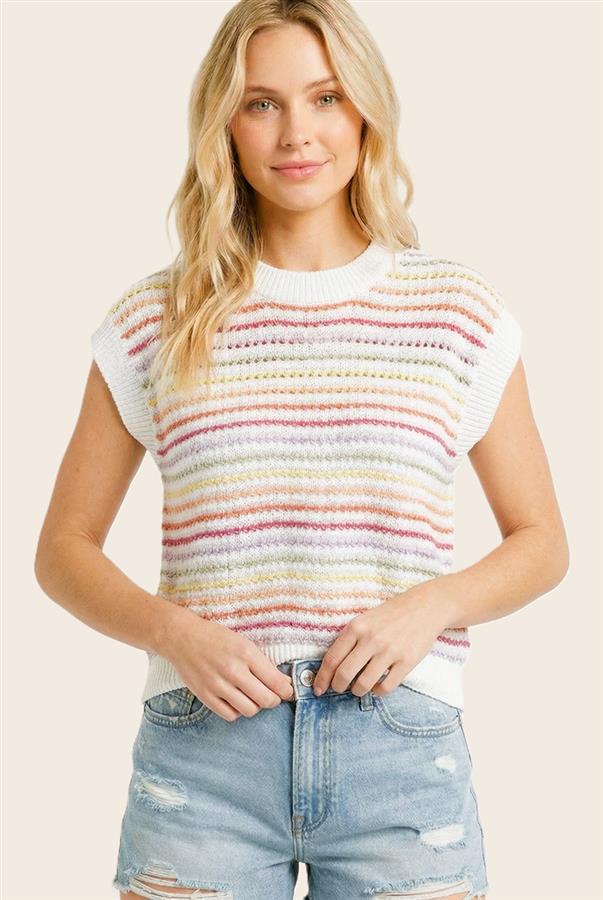 Woman wearing a colorful striped shirt and denim shorts on a plain background