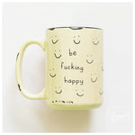 Yellow mug with smiley faces and text 'be fucking happy' on a white background