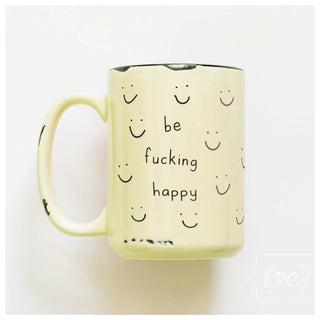 Yellow mug with smiley faces and text 'be fucking happy' on a white background