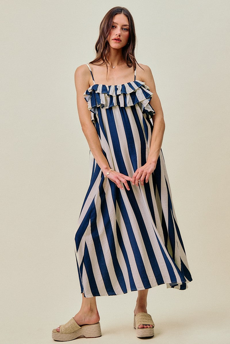Woman wearing a blue and white striped dress on a beige background