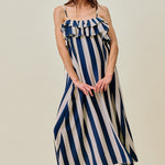 Woman wearing a blue and white striped dress on a beige background
