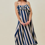Woman wearing a blue and white striped dress on a beige background