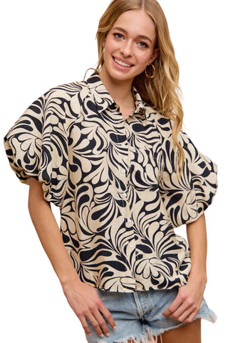 Woman wearing a patterned blouse with a pink background