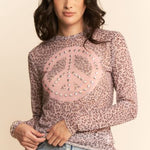 Woman wearing a leopard print top with a peace sign design on a beige background