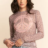 Woman wearing a leopard print top with a peace sign design on a beige background