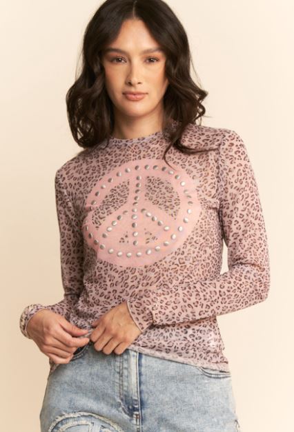 Woman wearing a leopard print top with a peace sign design on a beige background