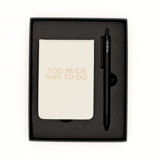 Notebook with 'Too Much Shit To Do' text and a pen in a black box on a white background