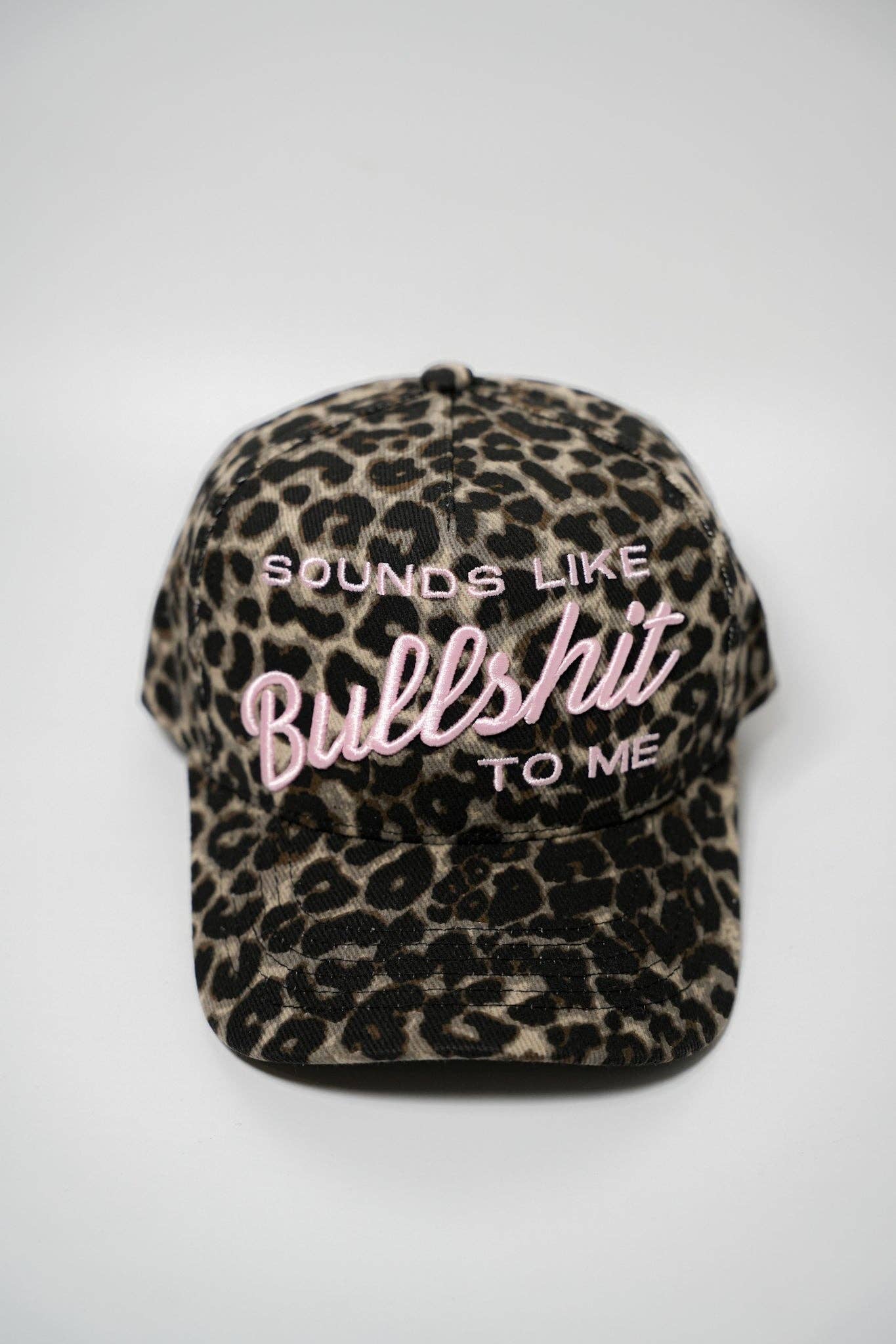 Leopard print cap with text 'SOUNDS LIKE BULLSHIT TO ME' on a white background