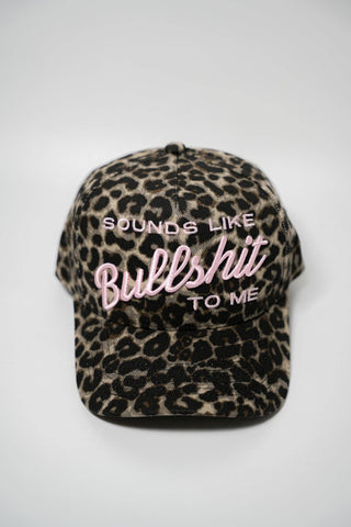 Leopard print cap with text 'SOUNDS LIKE BULLSHIT TO ME' on a white background