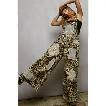 Woman wearing a leopard print jumpsuit with floral patterns against a plain background