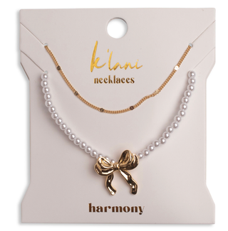Pearl necklace with a gold bow pendant on a 'klari necklaces' card.