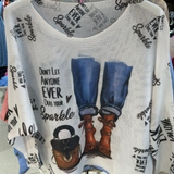 White tank top with denim, boots, and handbag graphic and text on a hanger.