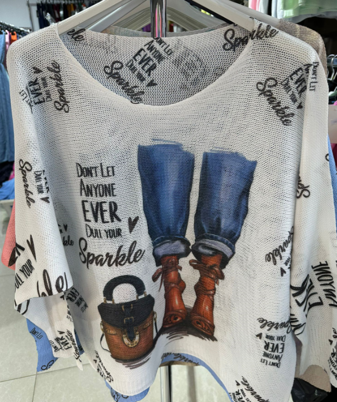 White tank top with denim, boots, and handbag graphic and text on a hanger.