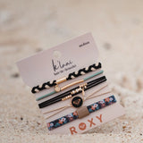 Set of hair ties and bracelets on a sand background