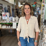 Woman standing in a store with various items and products in the background
