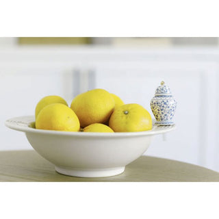 White bowl with lemons on a wooden surface