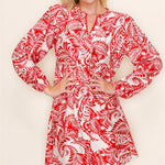 Woman wearing a red and white patterned dress against a plain background