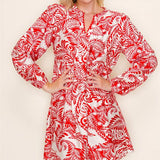 Woman wearing a red and white patterned dress against a plain background