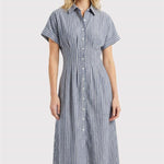 Woman wearing a blue and white striped dress on a light gray background