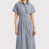 Woman wearing a blue and white striped dress on a light gray background