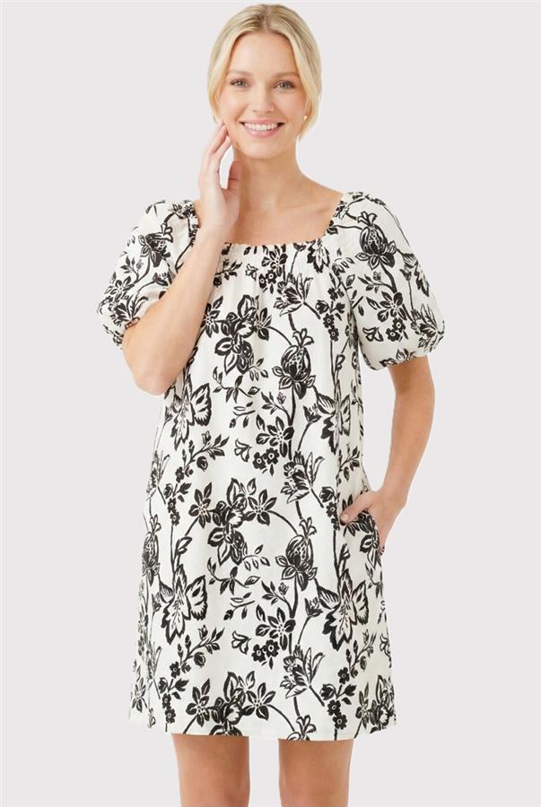 Woman wearing a black floral dress on a light gray background