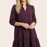 Woman wearing a purple dress on a beige background