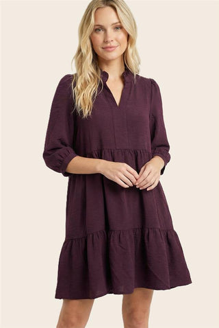 Woman wearing a purple dress on a beige background