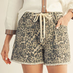 Leopard print shorts worn by a person on a neutral background