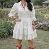 Woman in a white dress and red cowboy boots standing in a garden.