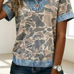Person wearing a camouflage shirt with denim collar and shorts indoors