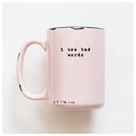 Pink mug with text 'i use bad words' on a white background