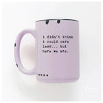 Purple mug with text 'i didn't think i could care less... but here we are.' on a white background