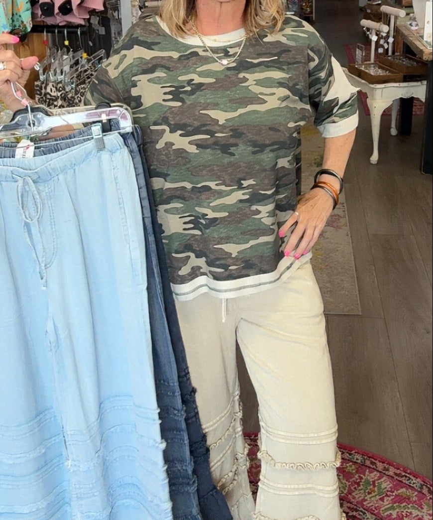 MODEL IN RUFFLE BOTTOM PANTS AND CAMO SHIRT
