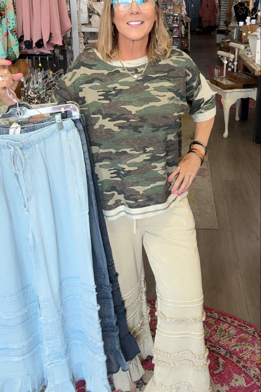 MODEL IN RUFFLE BOTTOM PANTS AND CAMO SHIRT
