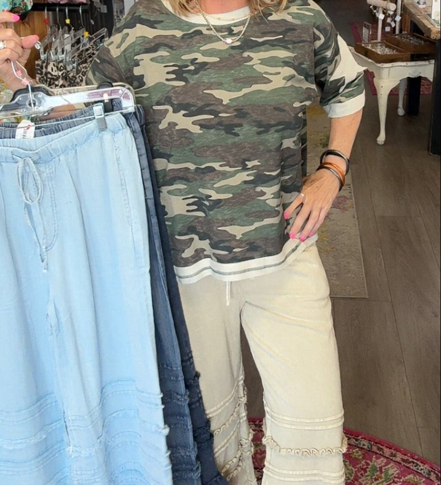 MODEL IN RUFFLE BOTTOM PANTS AND CAMO SHIRT
