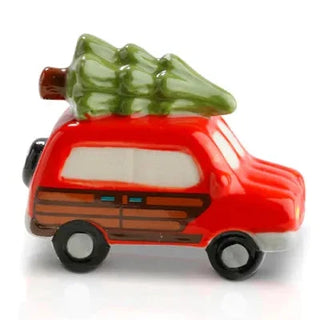 Red toy car with a Christmas tree on top against a white background