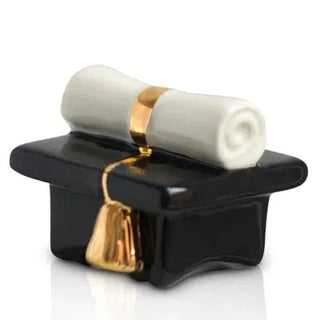 Decorative item with a black base, white cylindrical object, and gold accents on a white background