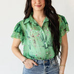 Woman wearing a green floral blouse and blue jeans on a white background