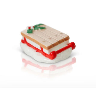 Miniature toy boat with a wooden deck and red frame on a white background
