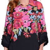 Woman wearing a black blouse with colorful floral patterns on a white background