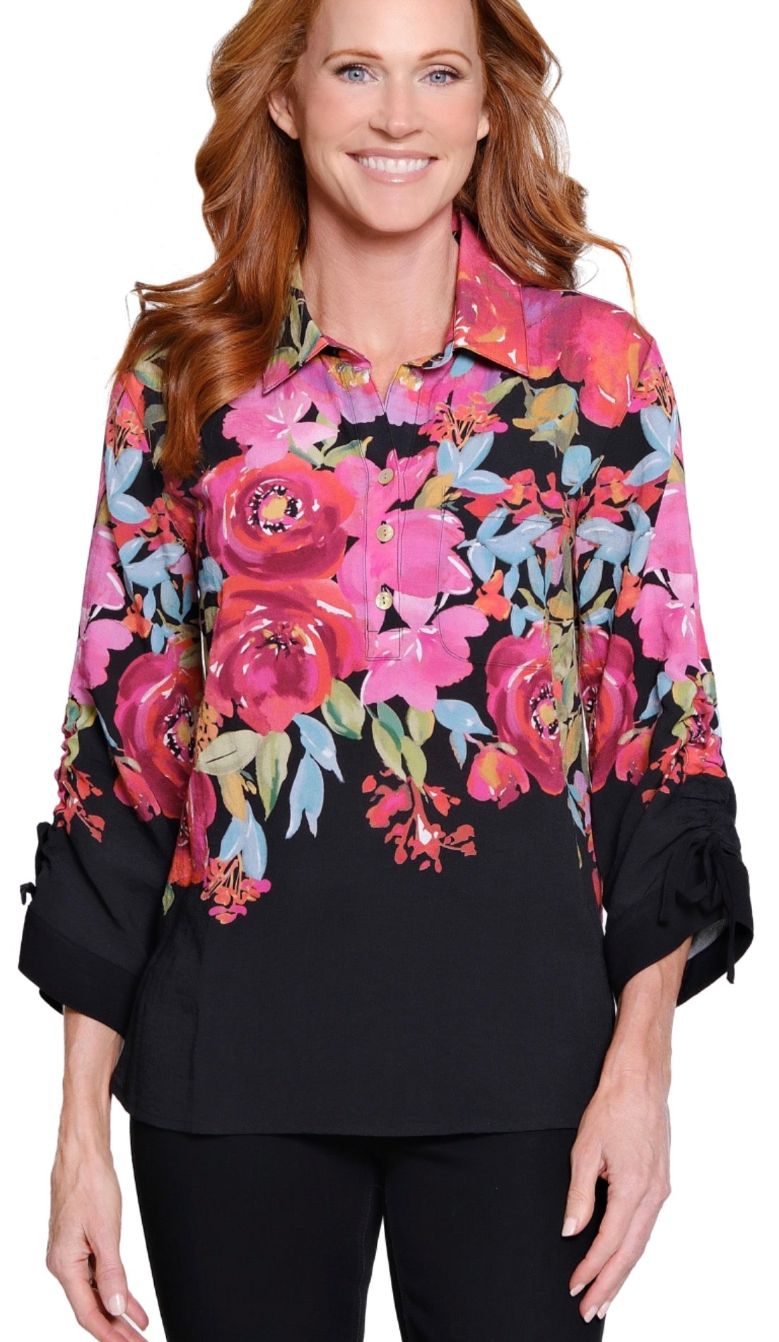 Woman wearing a black blouse with colorful floral patterns on a white background