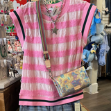 Pink striped shirt, jeans, and colorful bag on a mannequin in a store setting.