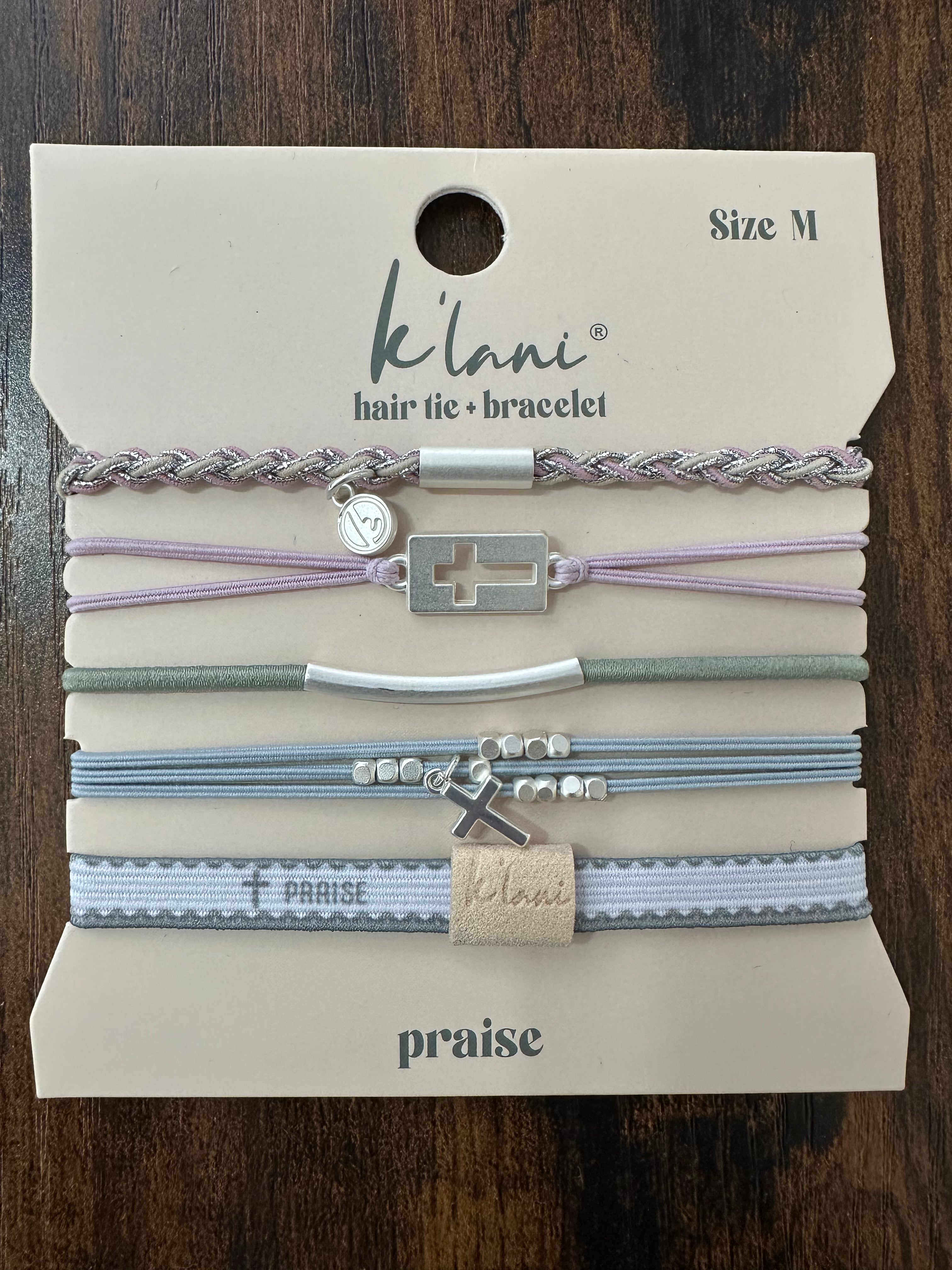 Set of hair ties and bracelets on a 'kilani' branded card with 'praise' text.