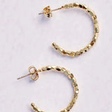 Gold hoop earrings on a light gray background